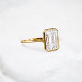 secret-glimmer-emerald-cut-bezel-moissanite-engagement-ring-4-ct-yellow-gold-gemfora-2